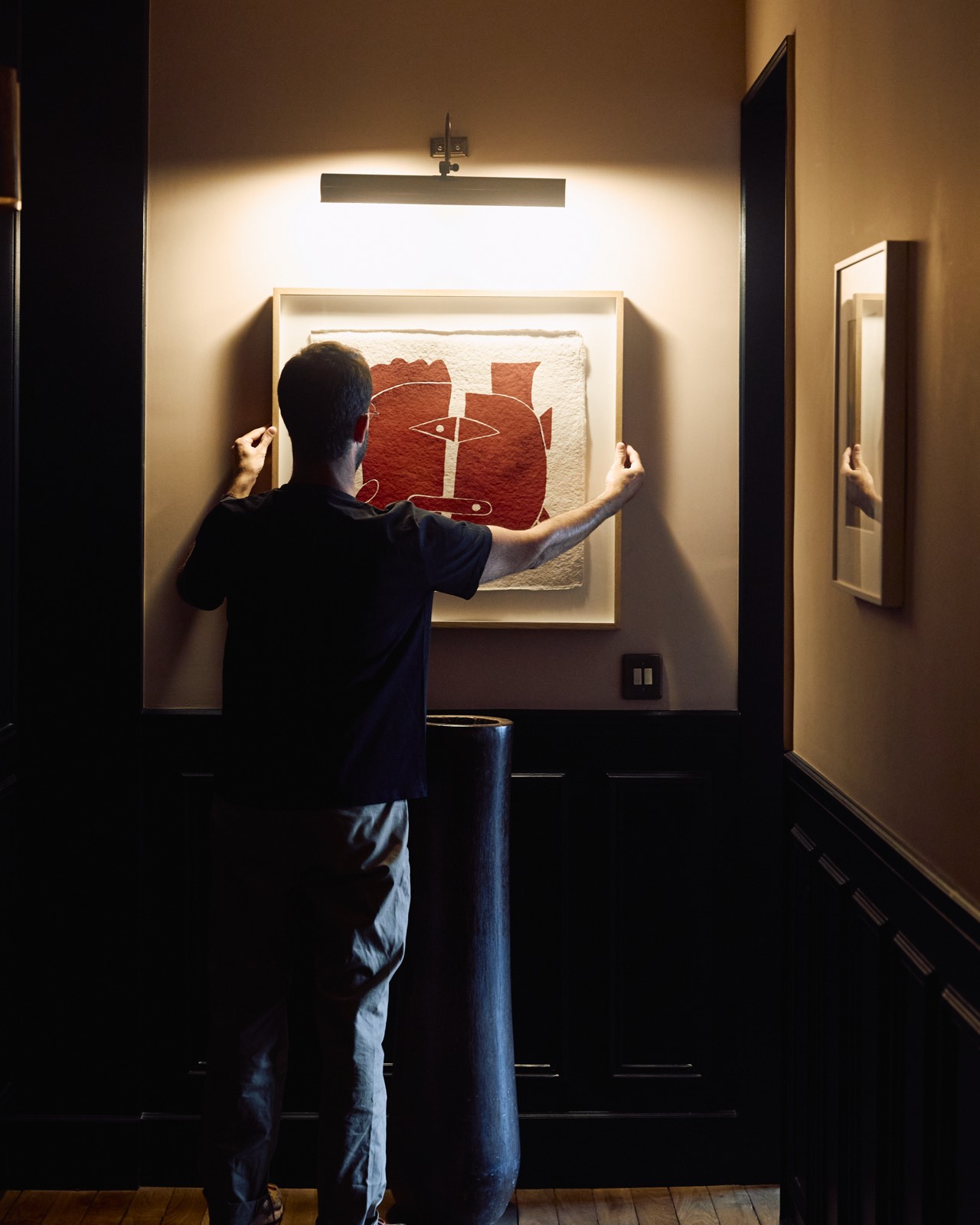 Laurent Sorbier hanging a work of art